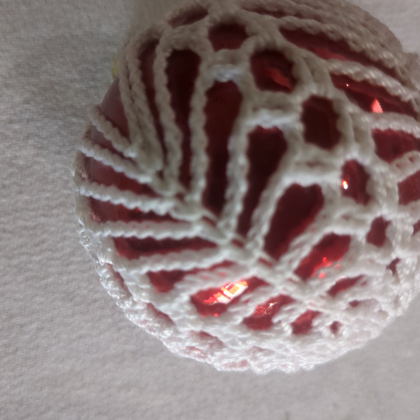 Red glass ornament with crochet