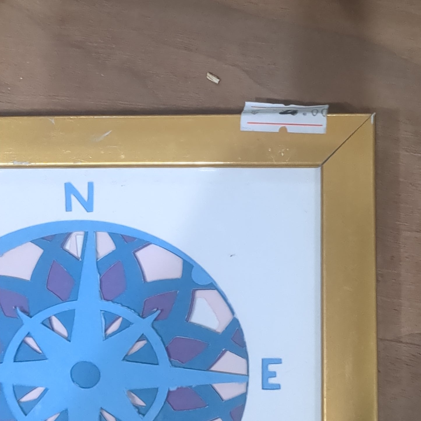 Roughly 5 x 6” gold shadow box with paper cut compass