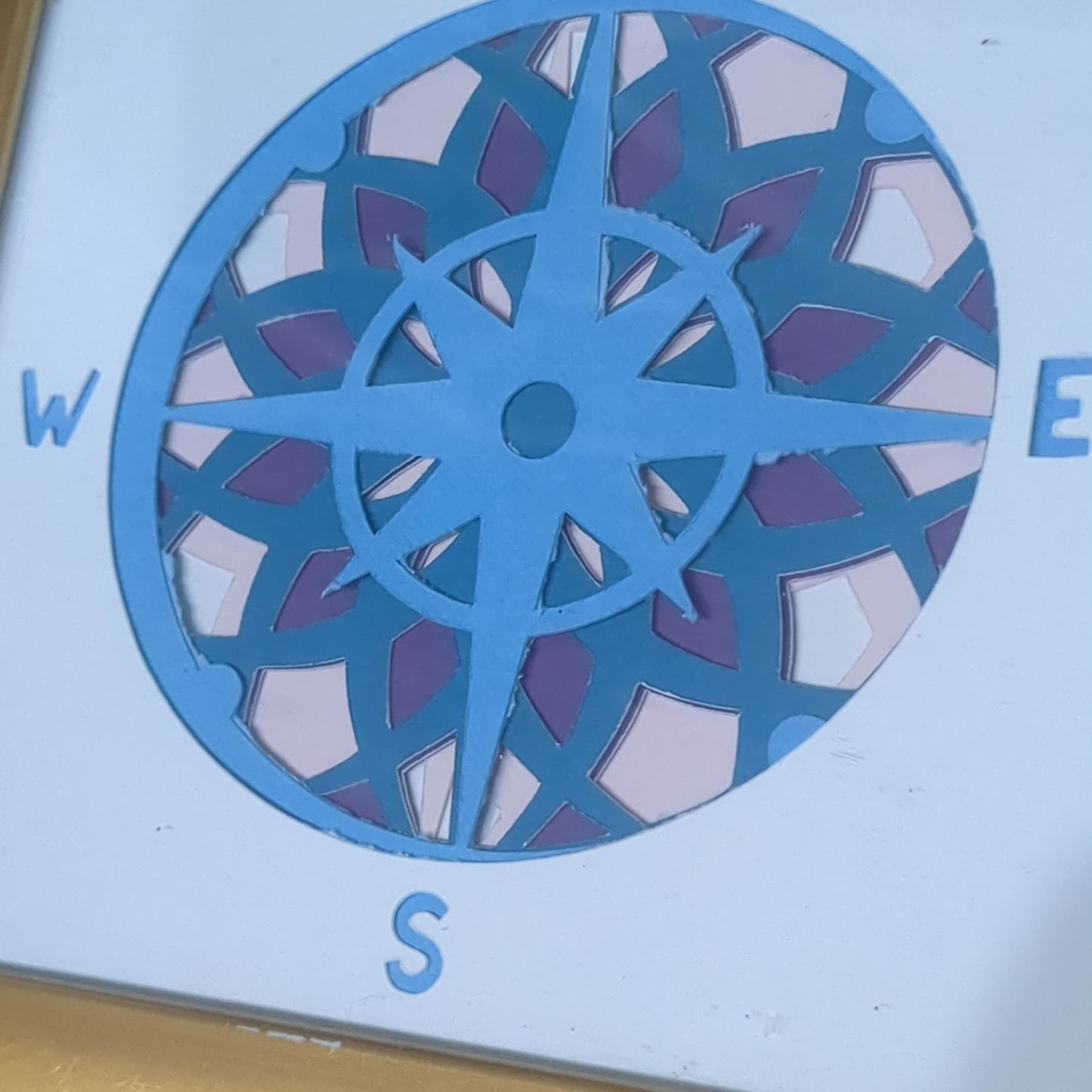 Roughly 5 x 6” gold shadow box with paper cut compass