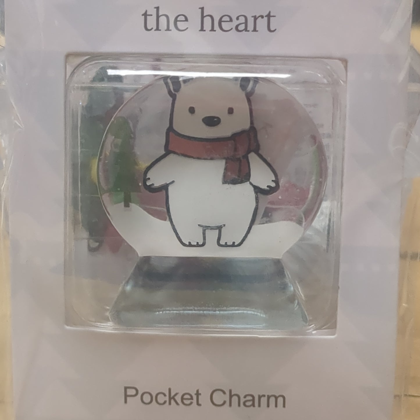 Pocket charm snow globe appearance with polar bear inside. Christmas warms the heart