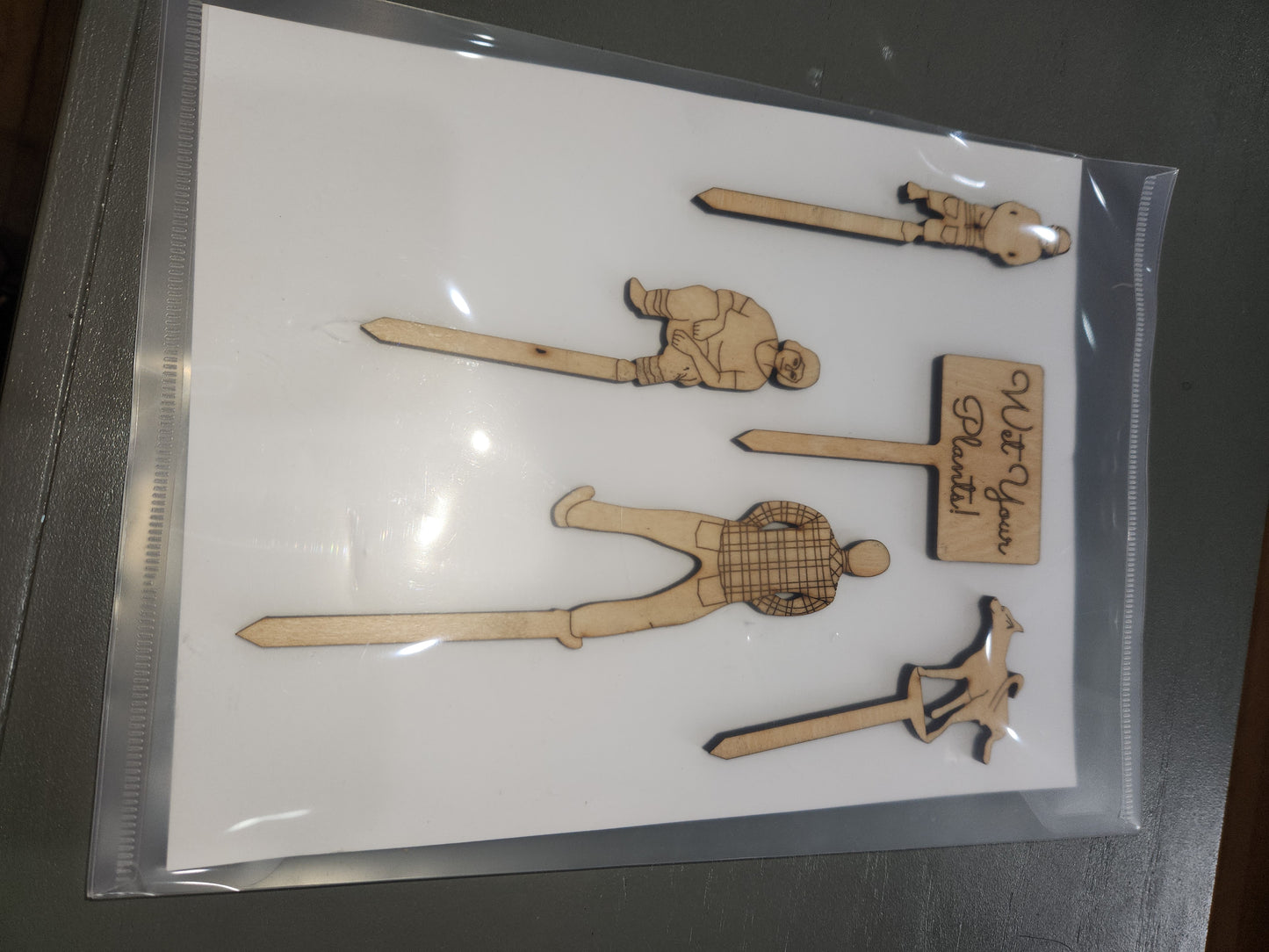 Wet Your Plants potting plant stakes dog, man, woman boy