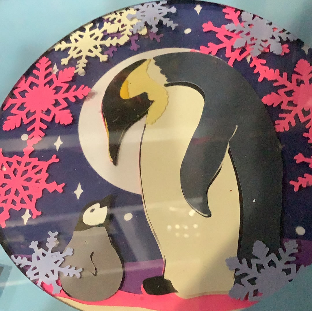 5 1/2” x 5 1/2” black shadow box frame with paper cut penguins scene