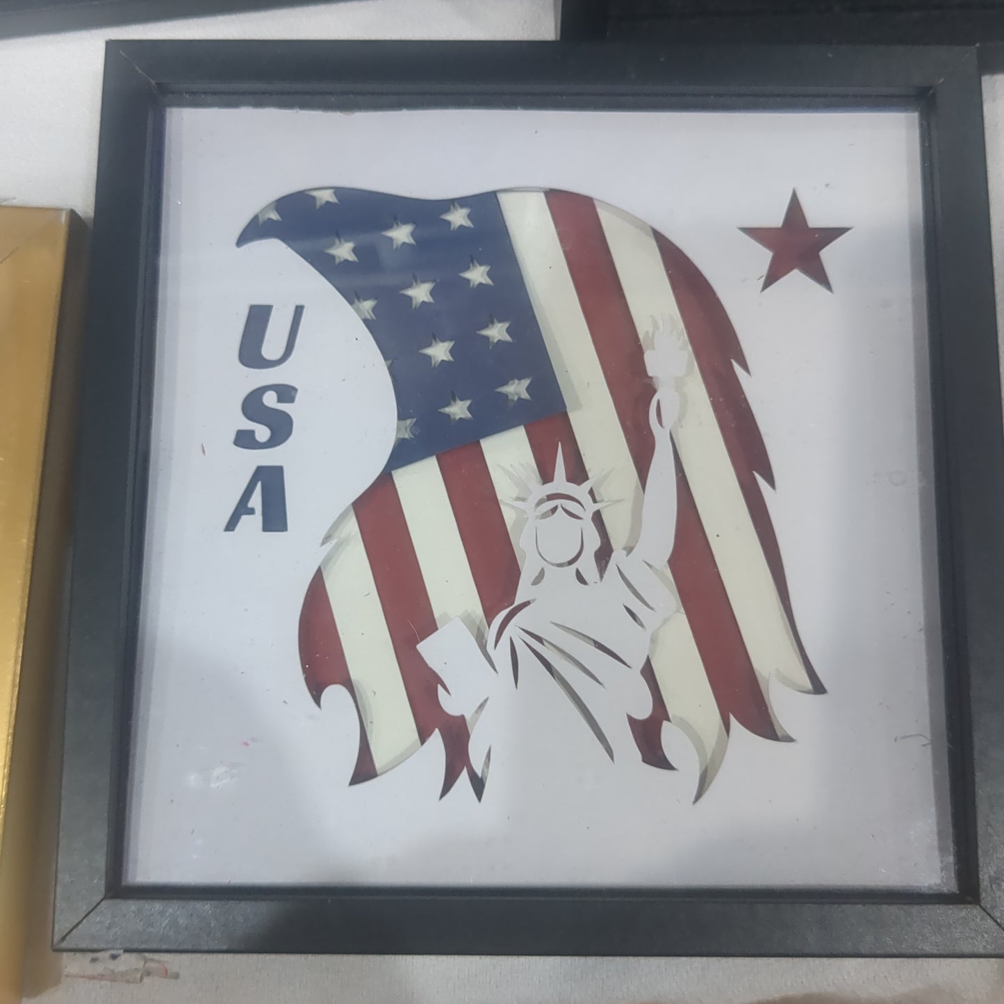 5 1/2” x 5 1/2” black shadow box with paper cut eagle Statue of Liberty and flag