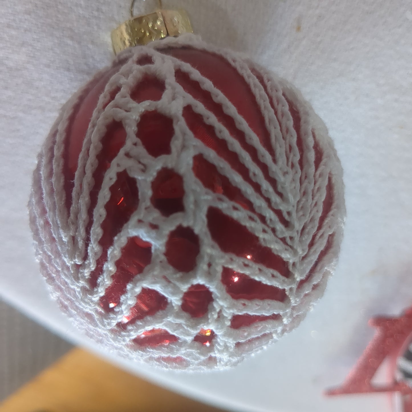 Red glass ornament with crochet