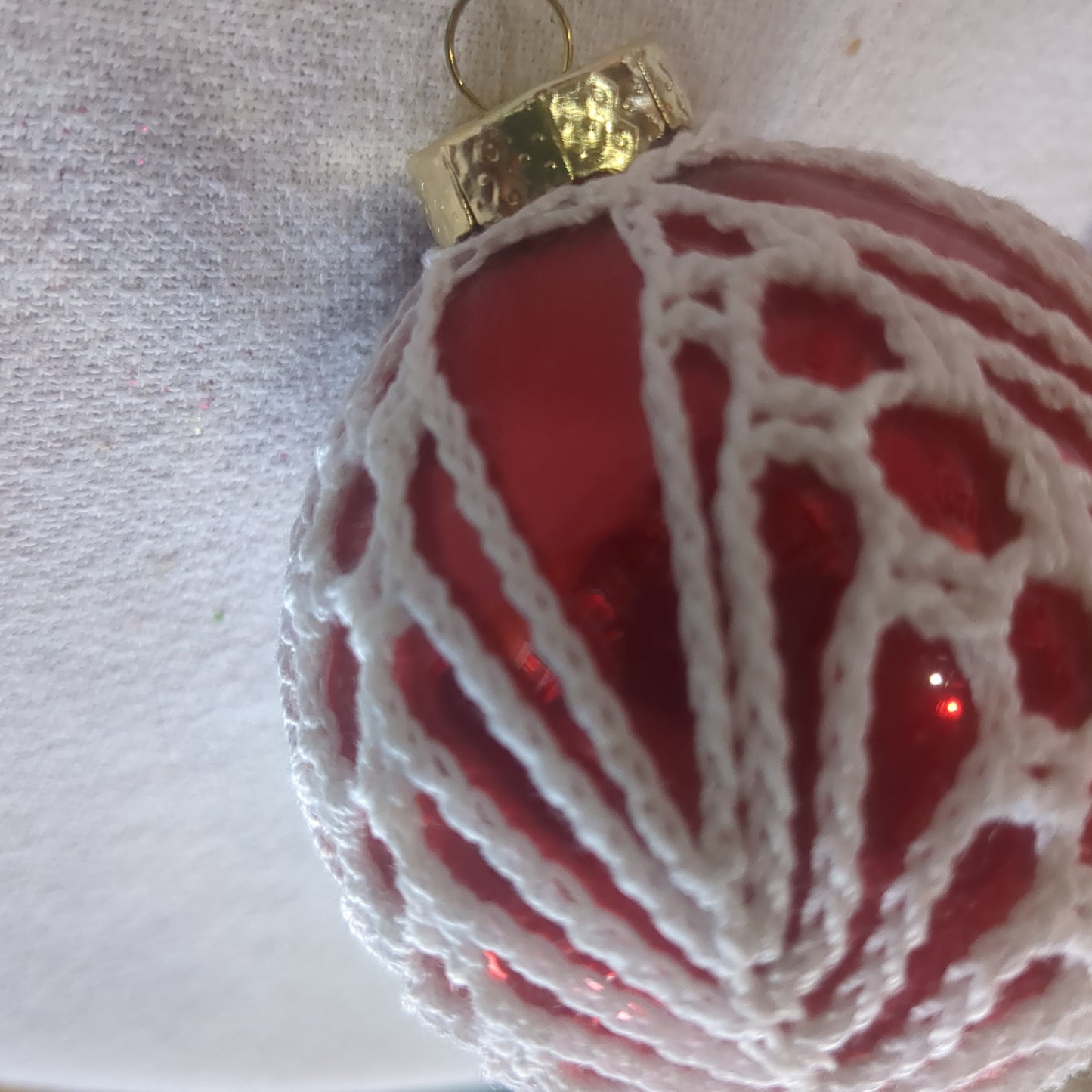 Red glass ornament with crochet