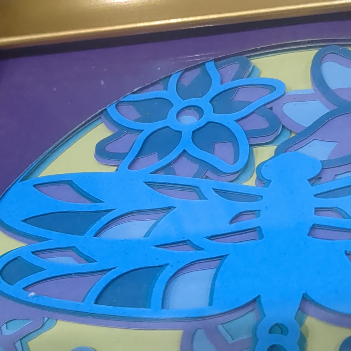 Roughly 5 by 6 inch gold shadow box with paper cut dragonfly