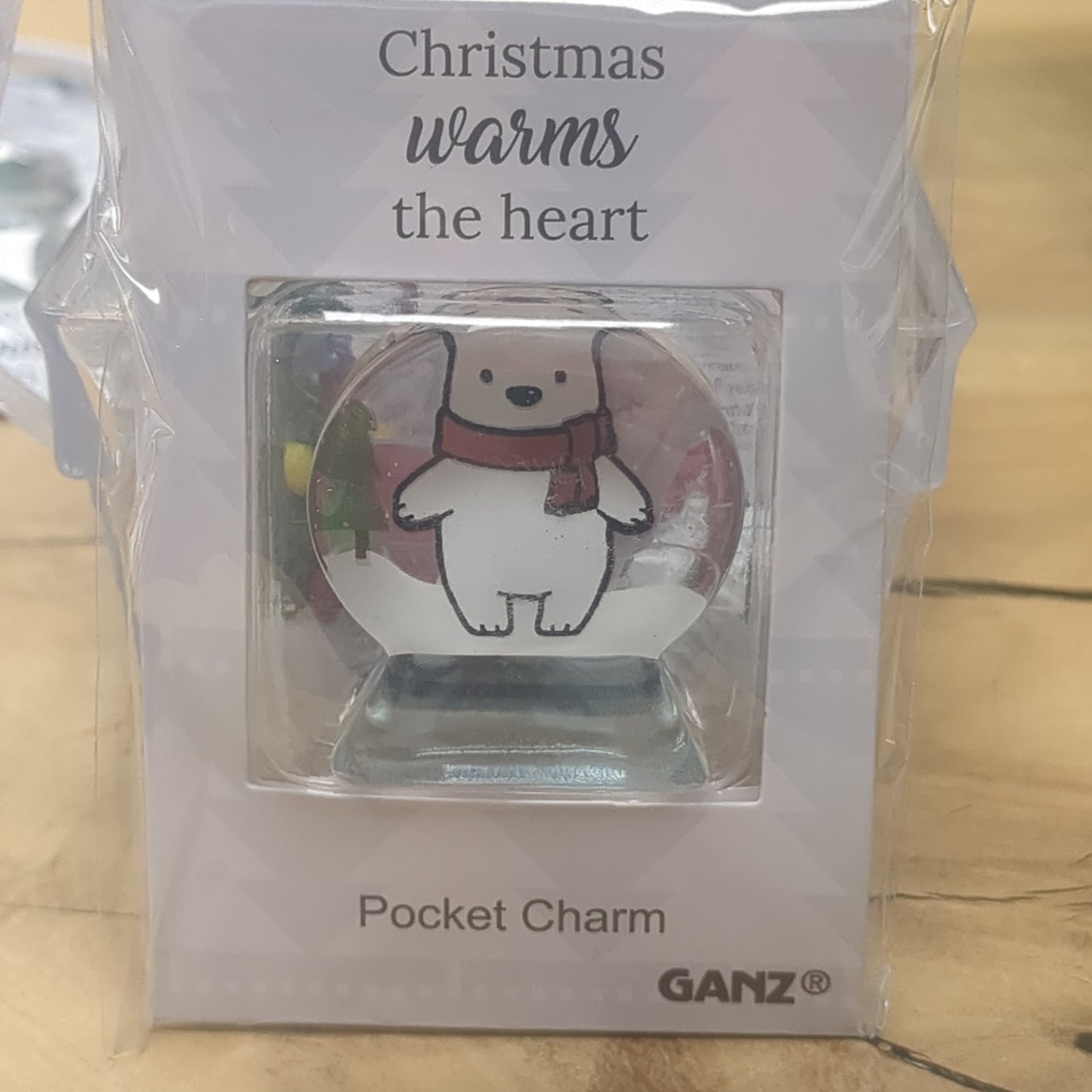 Pocket charm snow globe appearance with polar bear inside. Christmas warms the heart