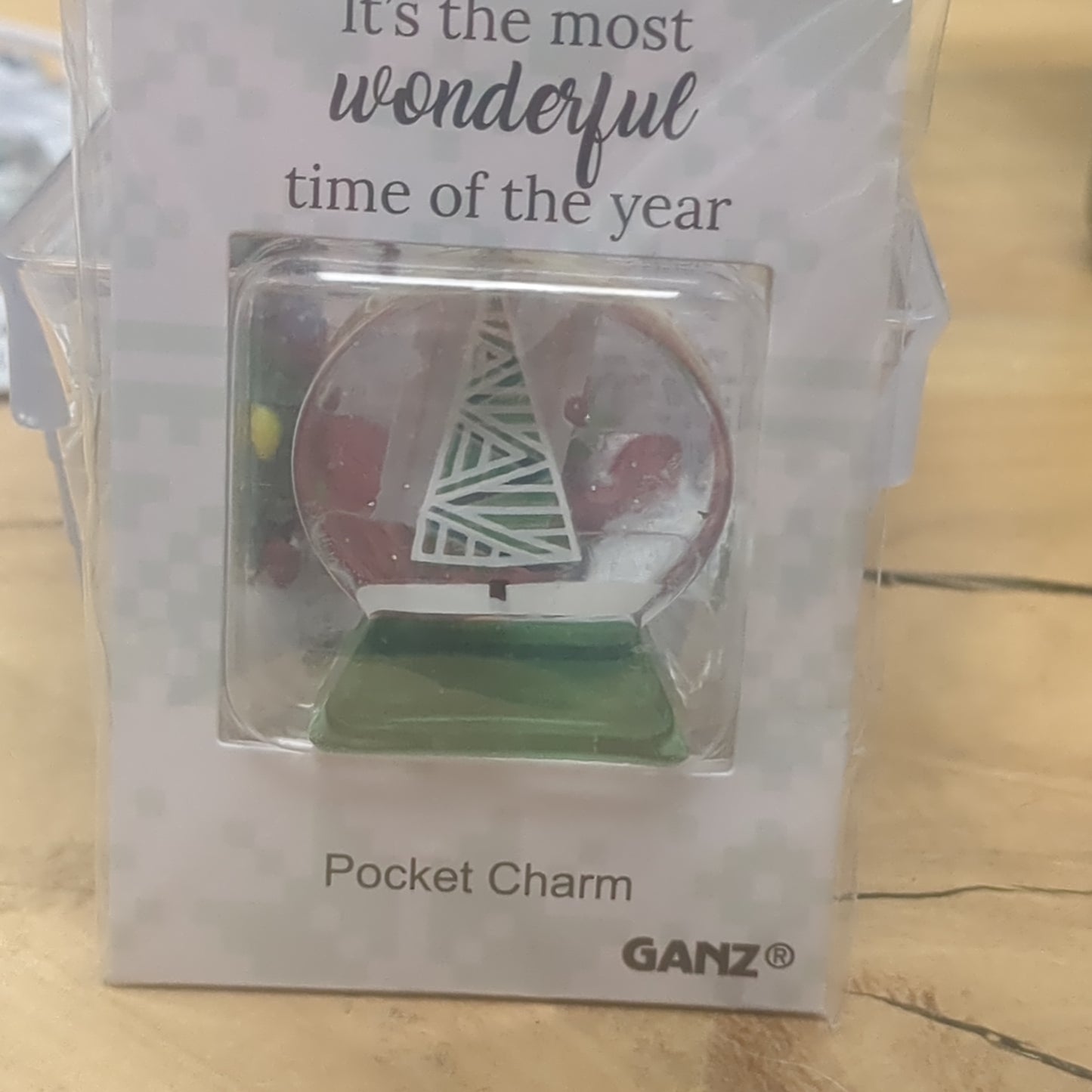 Pocket charm snow globe appearance with tree inside. It's the most wonderful time of the year