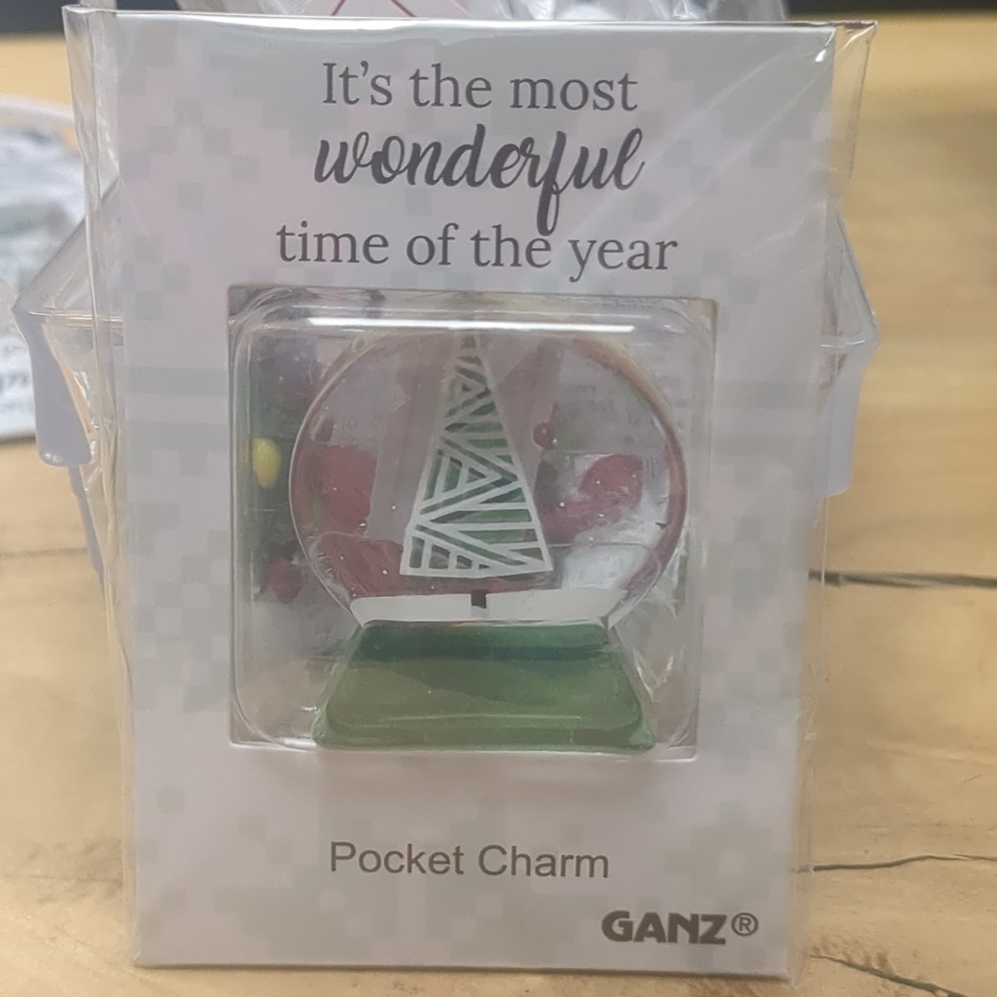 Pocket charm snow globe appearance with tree inside. It's the most wonderful time of the year