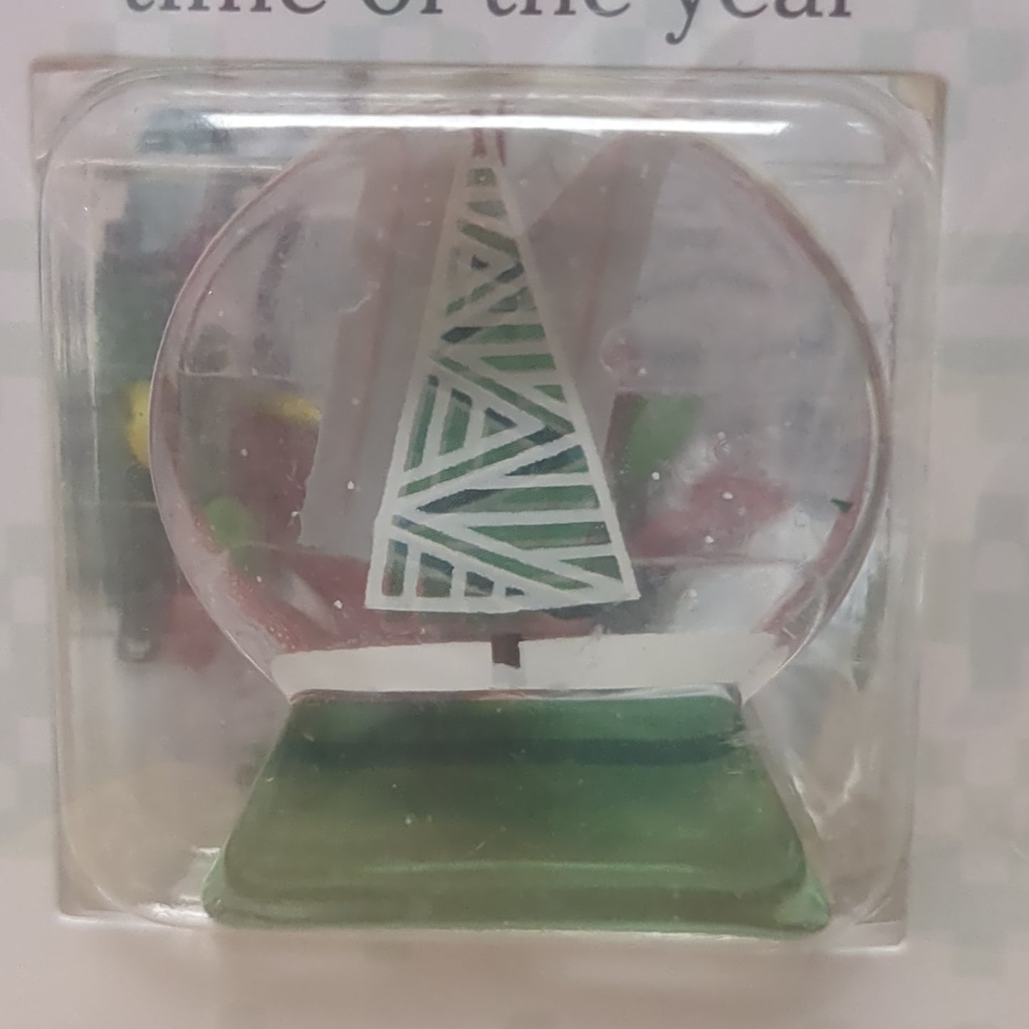 Pocket charm snow globe appearance with tree inside. It's the most wonderful time of the year