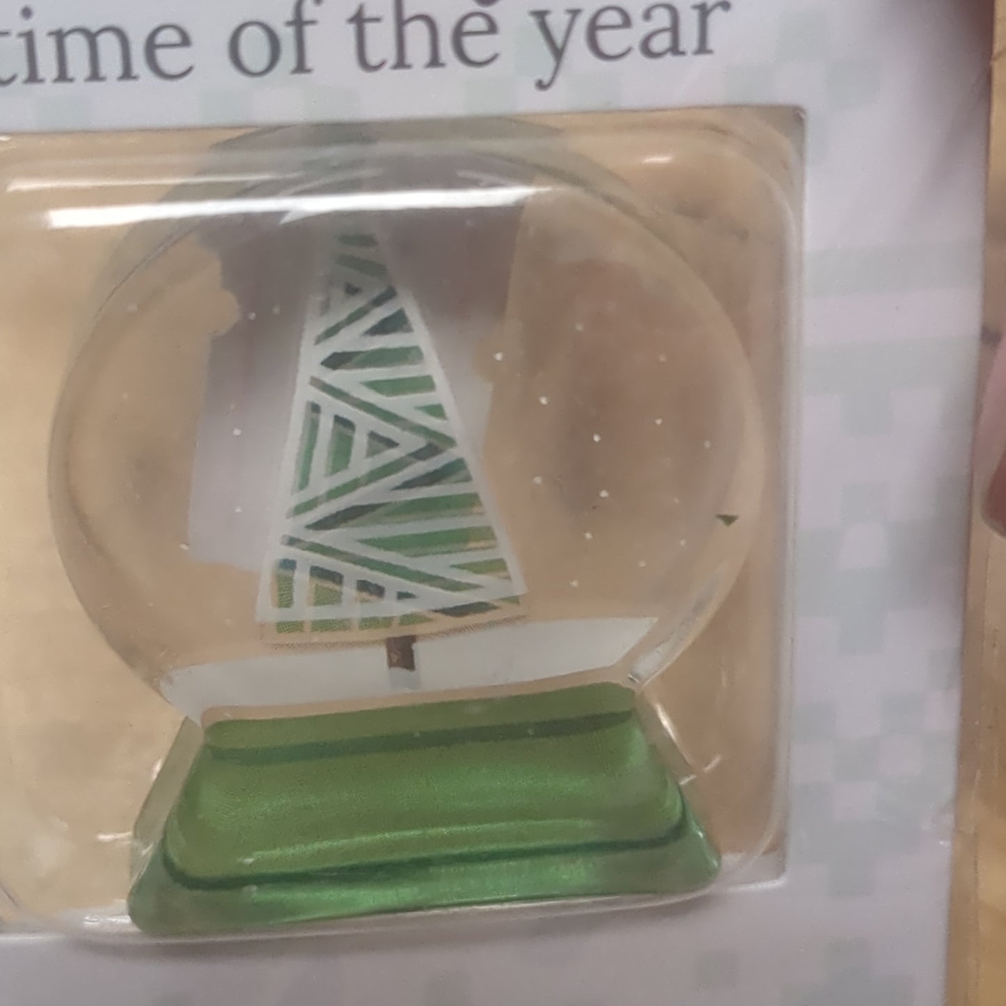 Pocket charm snow globe appearance with tree inside. It's the most wonderful time of the year