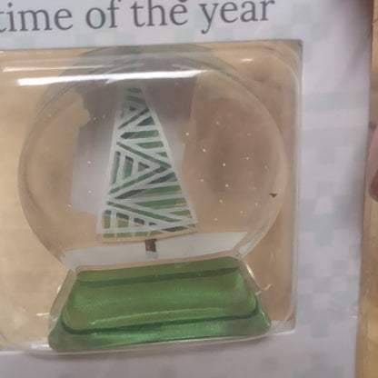 Pocket charm snow globe appearance with tree inside. It's the most wonderful time of the year
