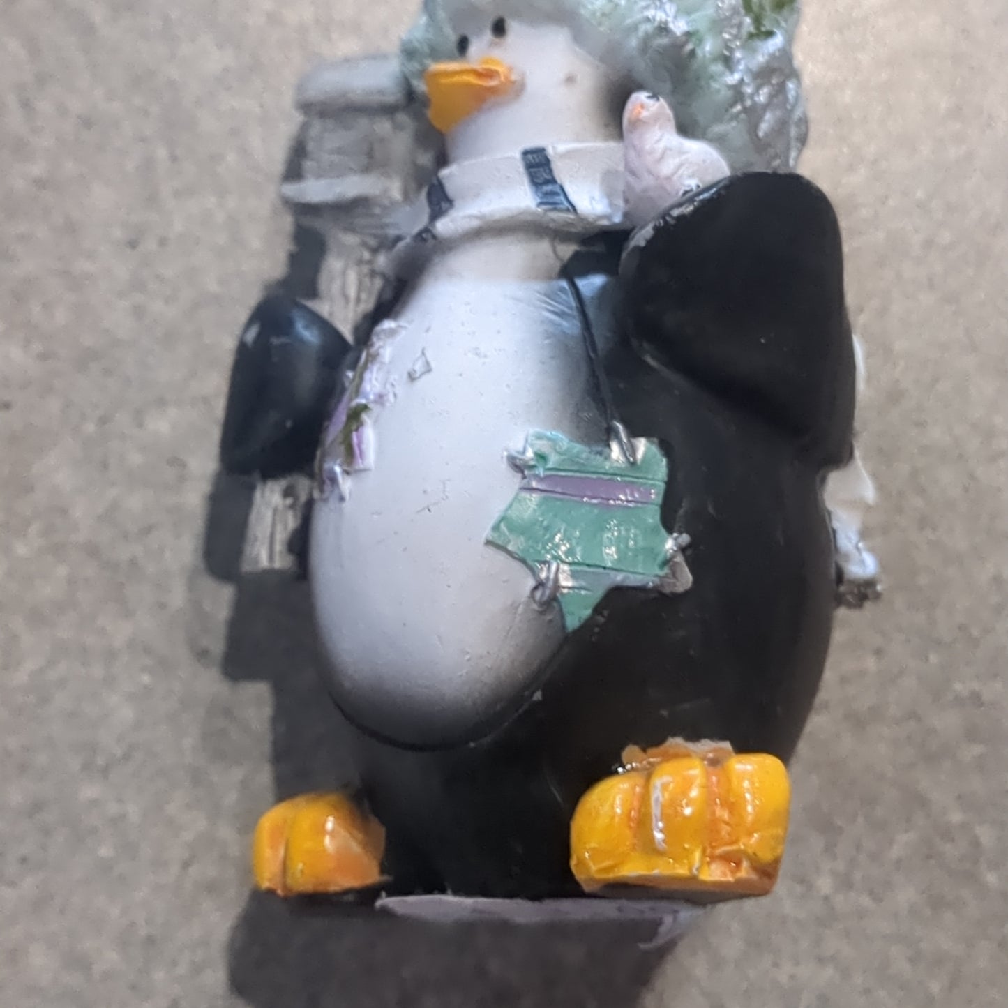 Penguin ornament with a bird and a birdhouse
