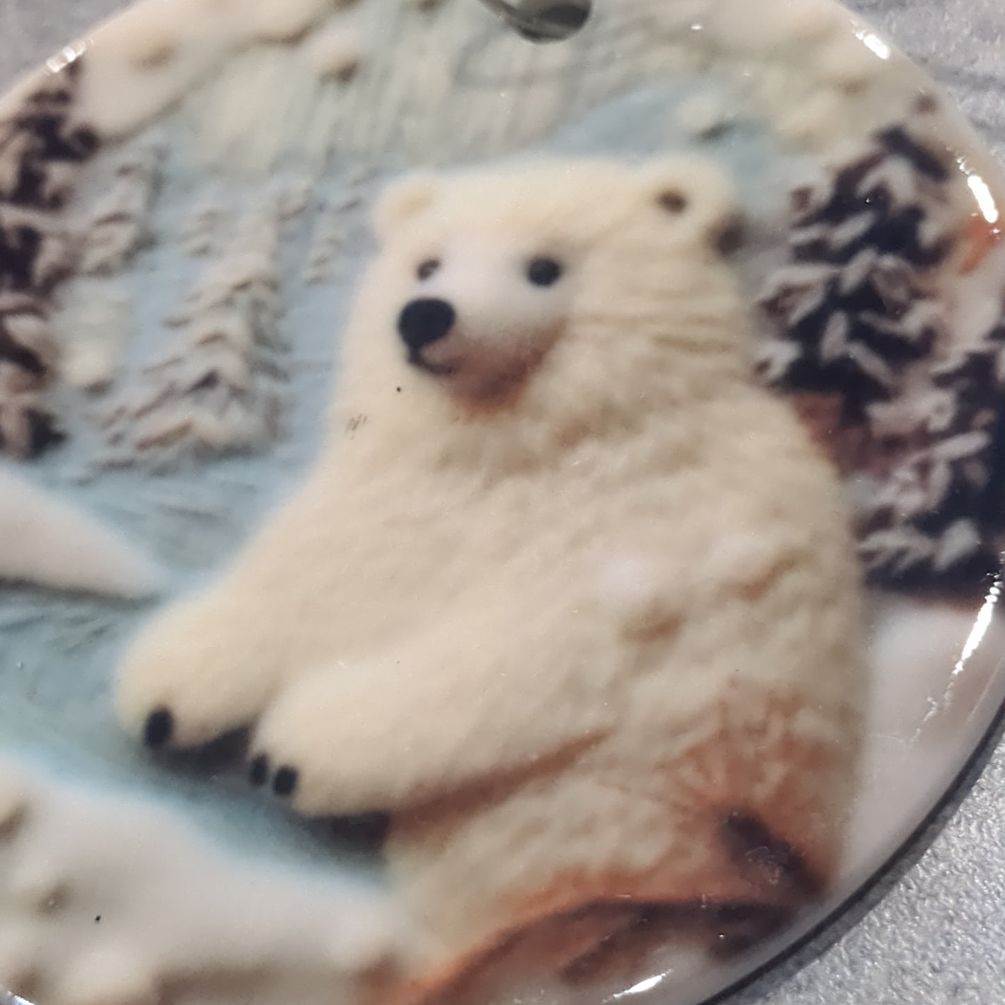Ceramic ornament with a polar bear the lake and mountains and trees in the background, it appears 3D but it is not