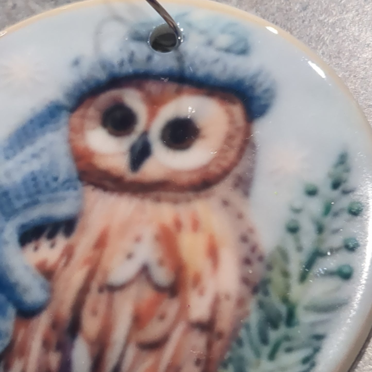 Ceramic ornament owl with a blue hat and a blue scarf, it appears 3D but it is not