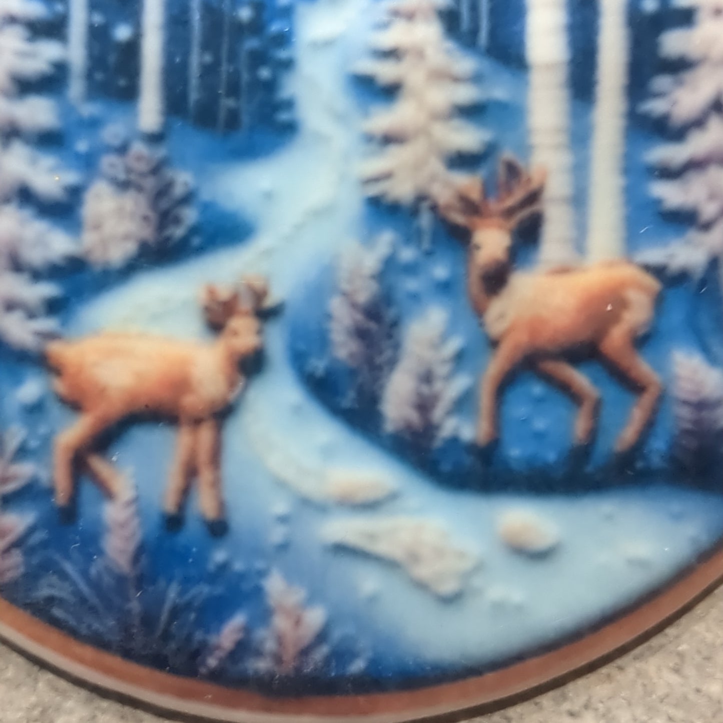 Ceramic ornament with a pair of deer by a river in the forest, it appears 3D but it is not