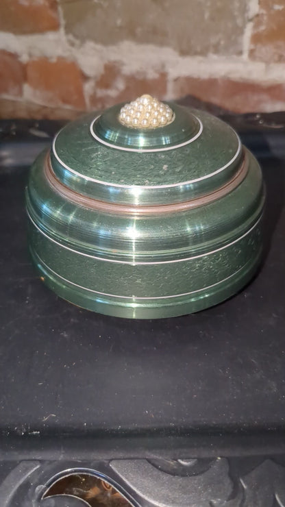 Vintage, round, aluminum, powder puff music box with faux pearls on top. Mb1